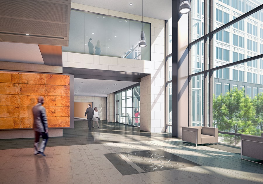 Visitor walking through a bright, glass-walled hospital lobby
