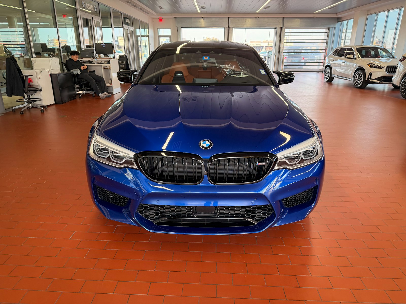 Blue sedan on a red-floored dealership showroom
