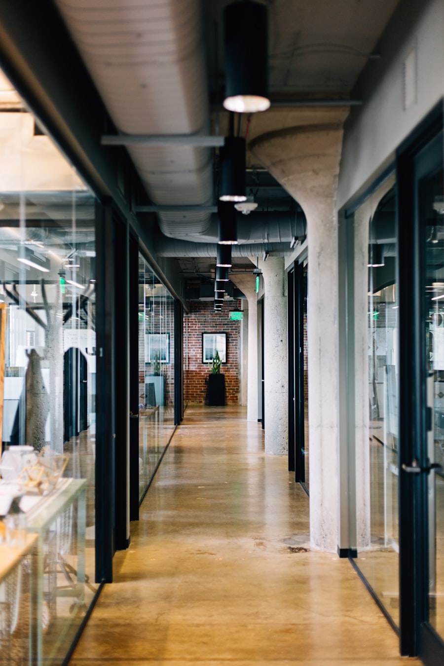Glass-walled office corridor with concrete columns
