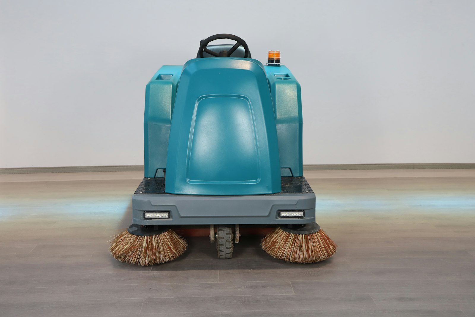 Ride-on floor scrubber with rotating front brushes
