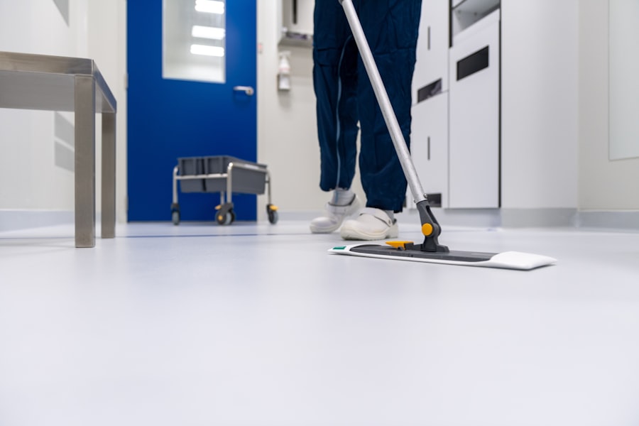 Cleaner in blue mopping a clinic corridor floor