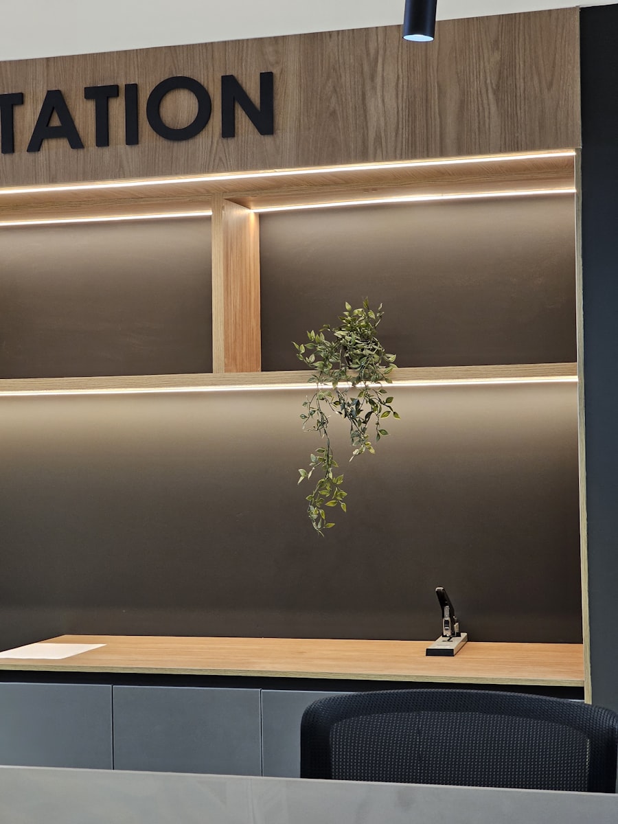 Reception desk with a small plant beneath a wall sign