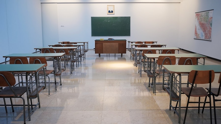 Empty classroom with desks facing a green chalkboard